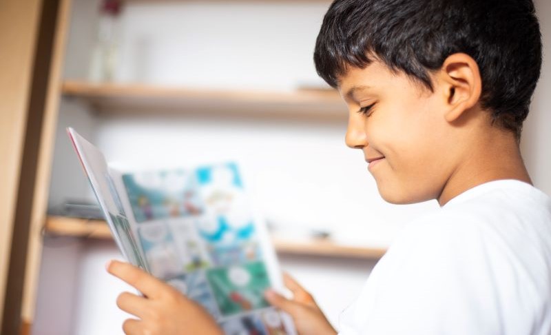 Young student reading a comic book.